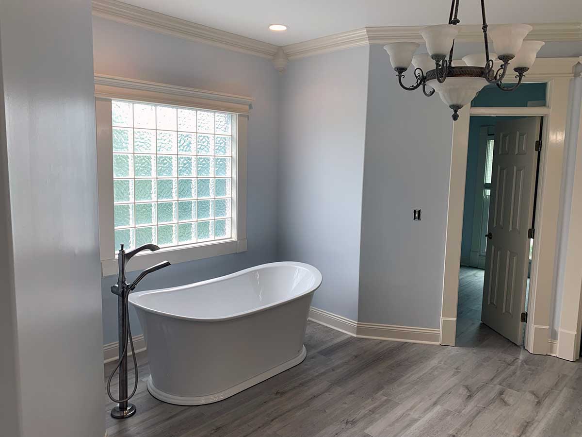 Repair Masterz master bathroom remodel with soaking tub and frosted glass window.